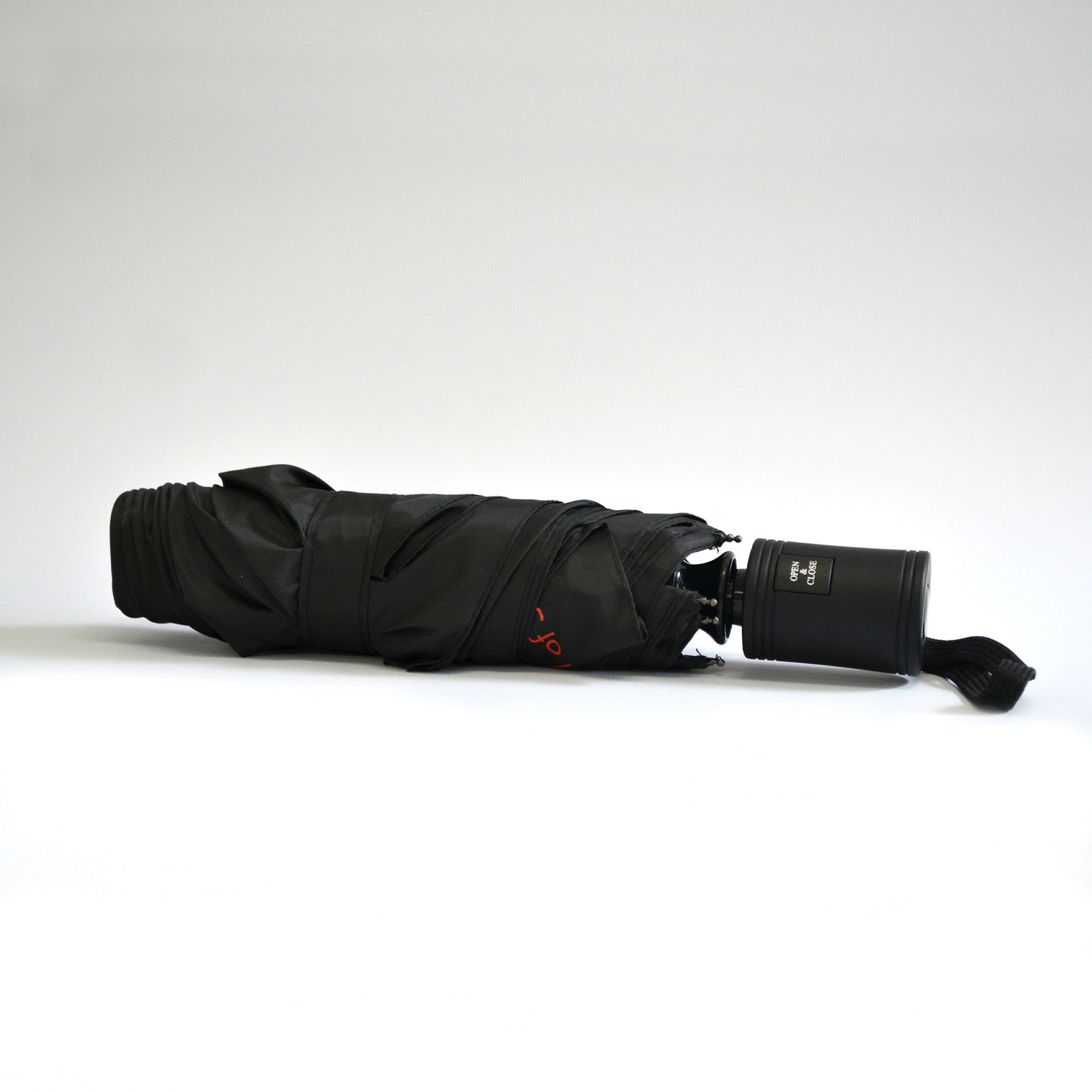 Small folded up black umbrella