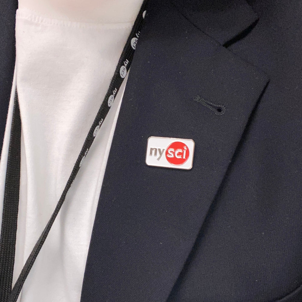 close-up of black suit with a white lapel pin with the NYSCI logo