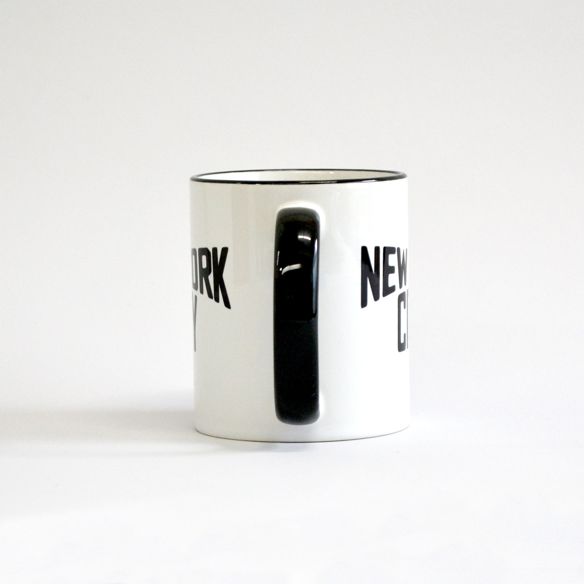 White coffee mug with black lettering of NEW YORK CITY - view of handle side