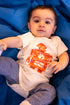 baby wearing vintage robot onesie on blue cloth background