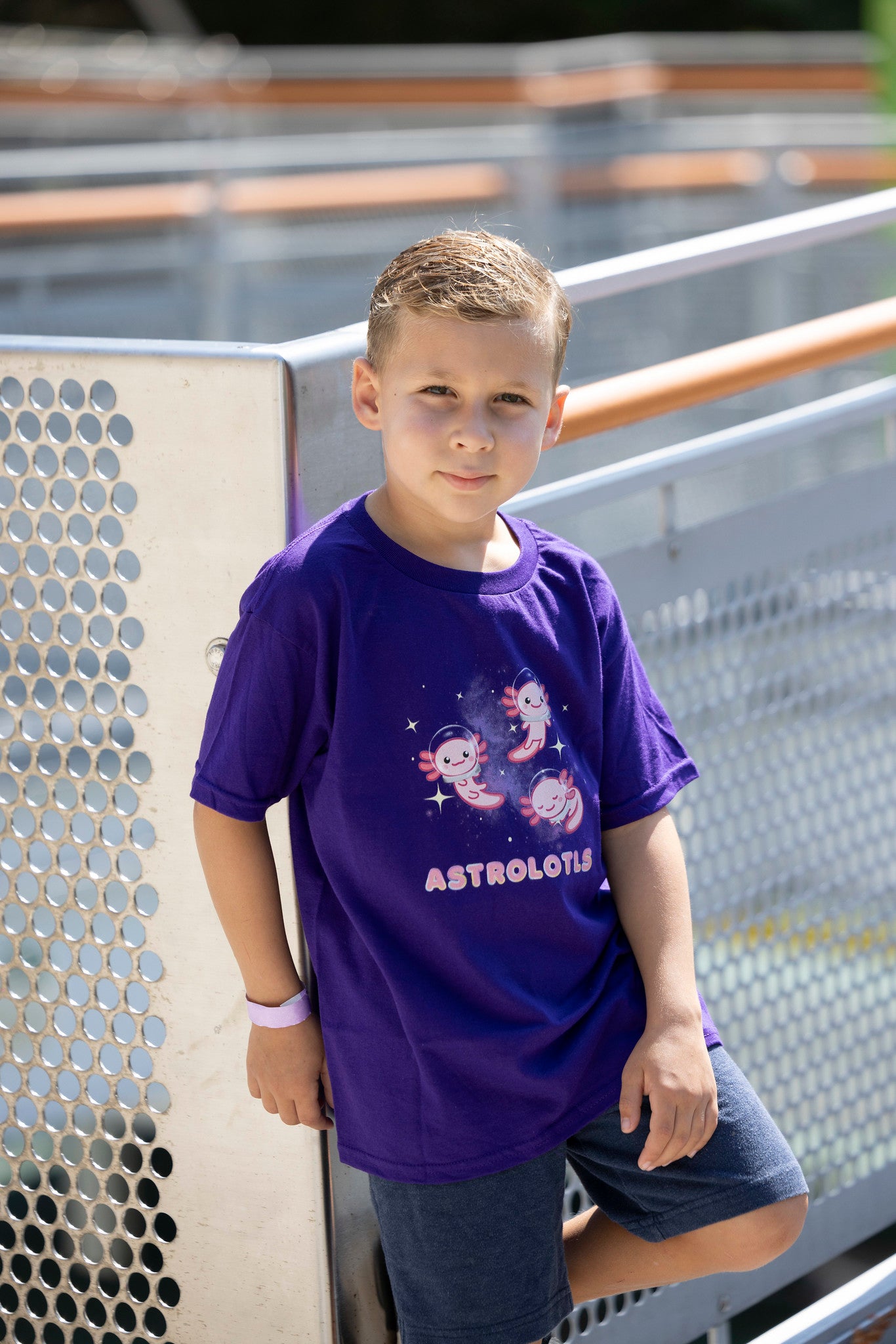 Boy posing wearing purple astrolotls t-shirt