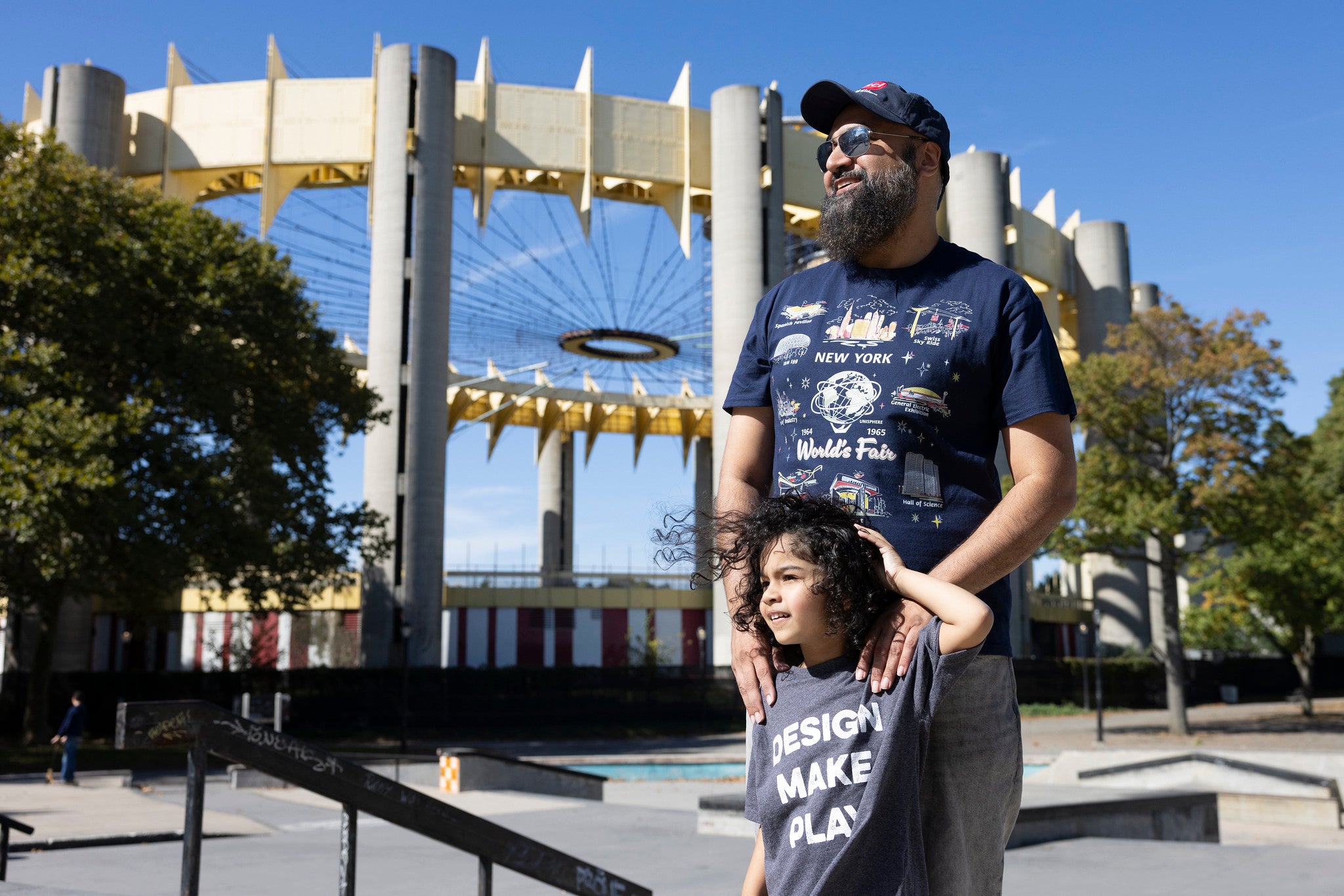 Man and child wearing nysci t-shirts in Corona Park with World&