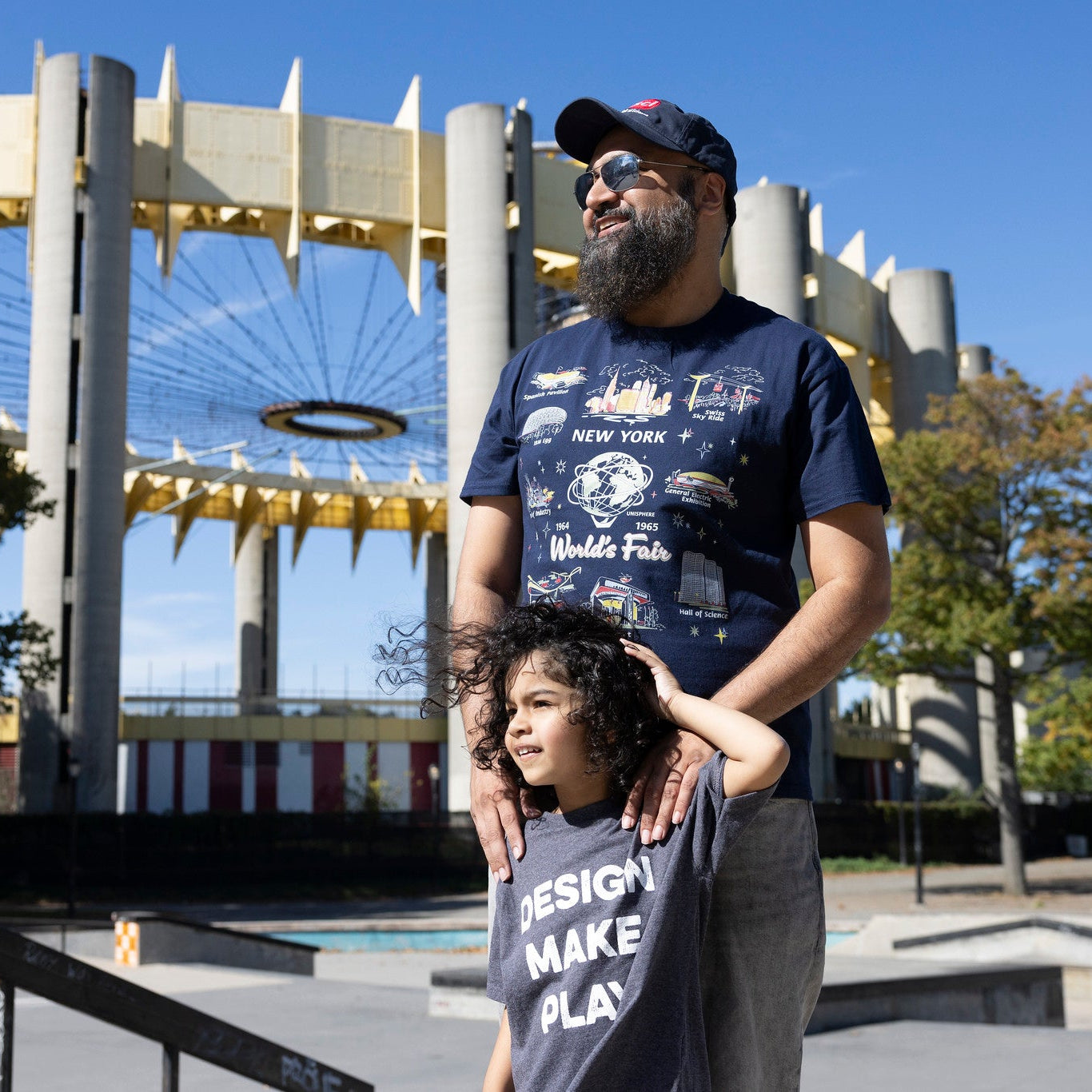 Man and child wearing nysci t-shirts in Corona Park with World&