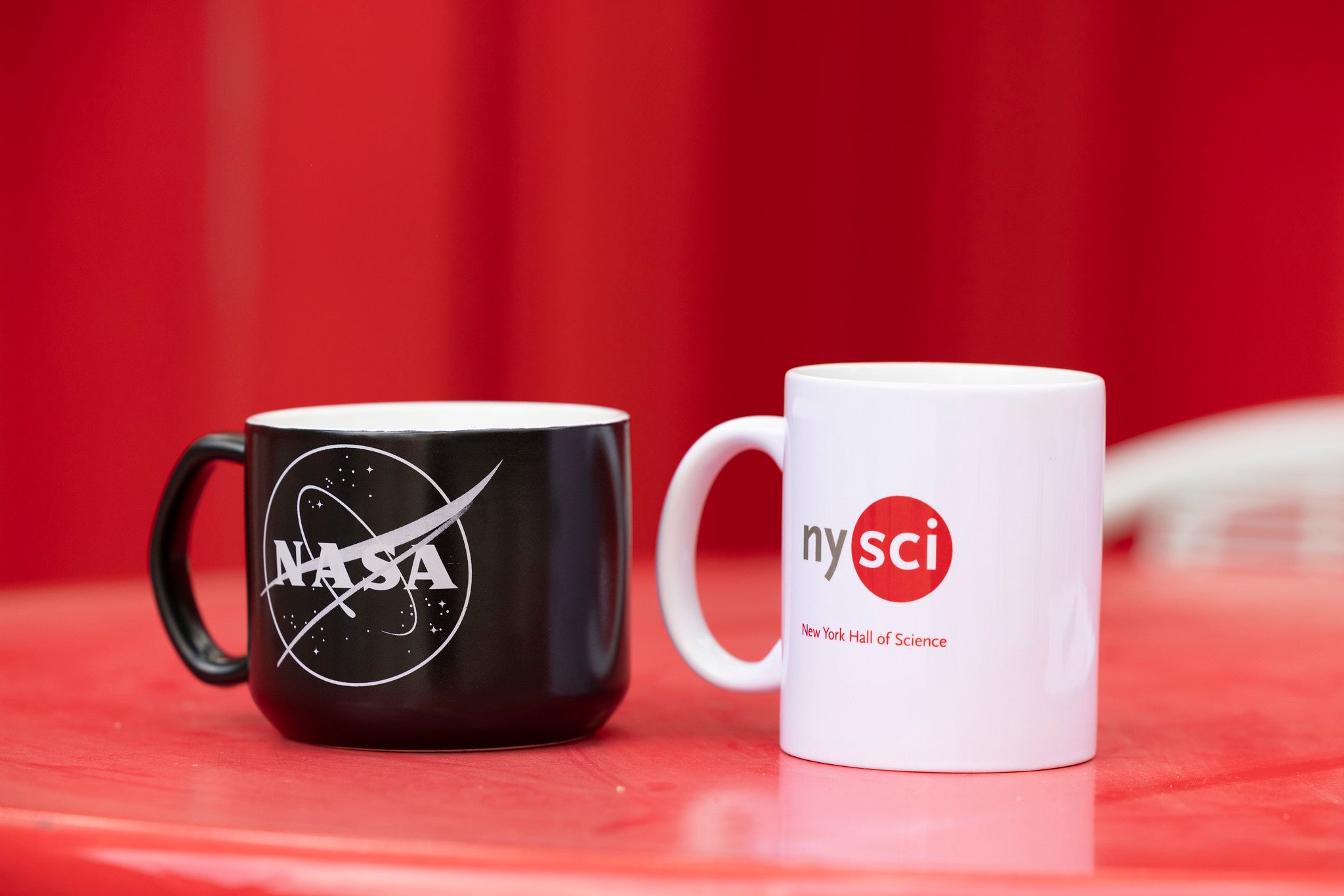 NASA mug and a white nysci branded mug