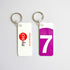 Photo of two keychains. One with logo of 7 train in purple and one with logo of the nysci museum