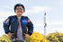 Boy posing in front of NASA rocket wearing NASA jacket and hat