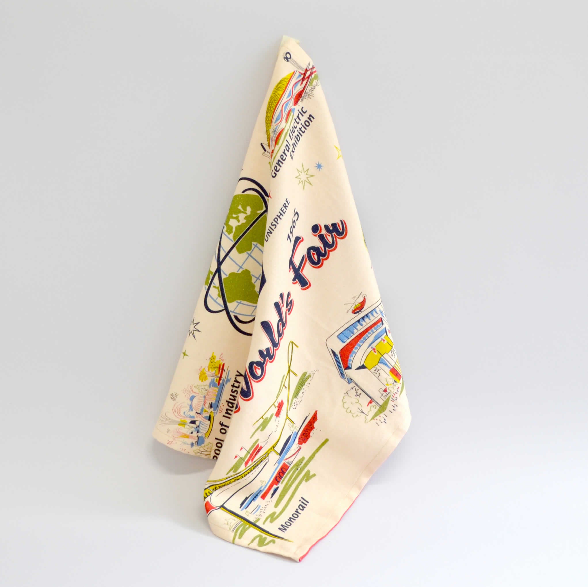 White tea towel draped hanging with images of the worlds fair buildings on it