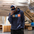 Person wearing a hoodie with THINK design logos in an indoor setting also wearing with baseball cap 