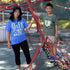 Adult woman wearing blue Queens graphic Tshirt with transit map standing outside