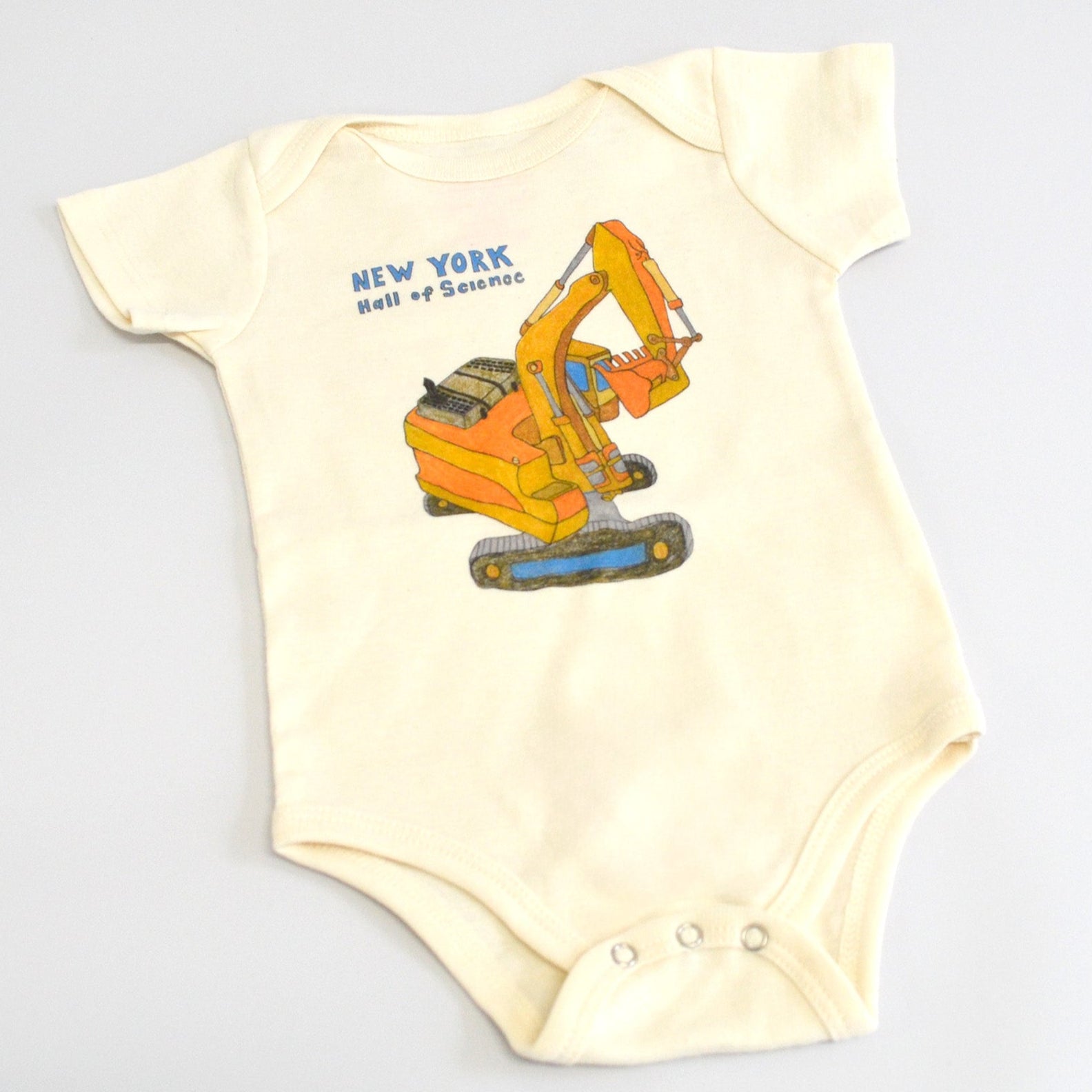 onesie with bulldozer design on white fabric