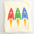 Onesie with red, green, and blue vintage rocket designs on it