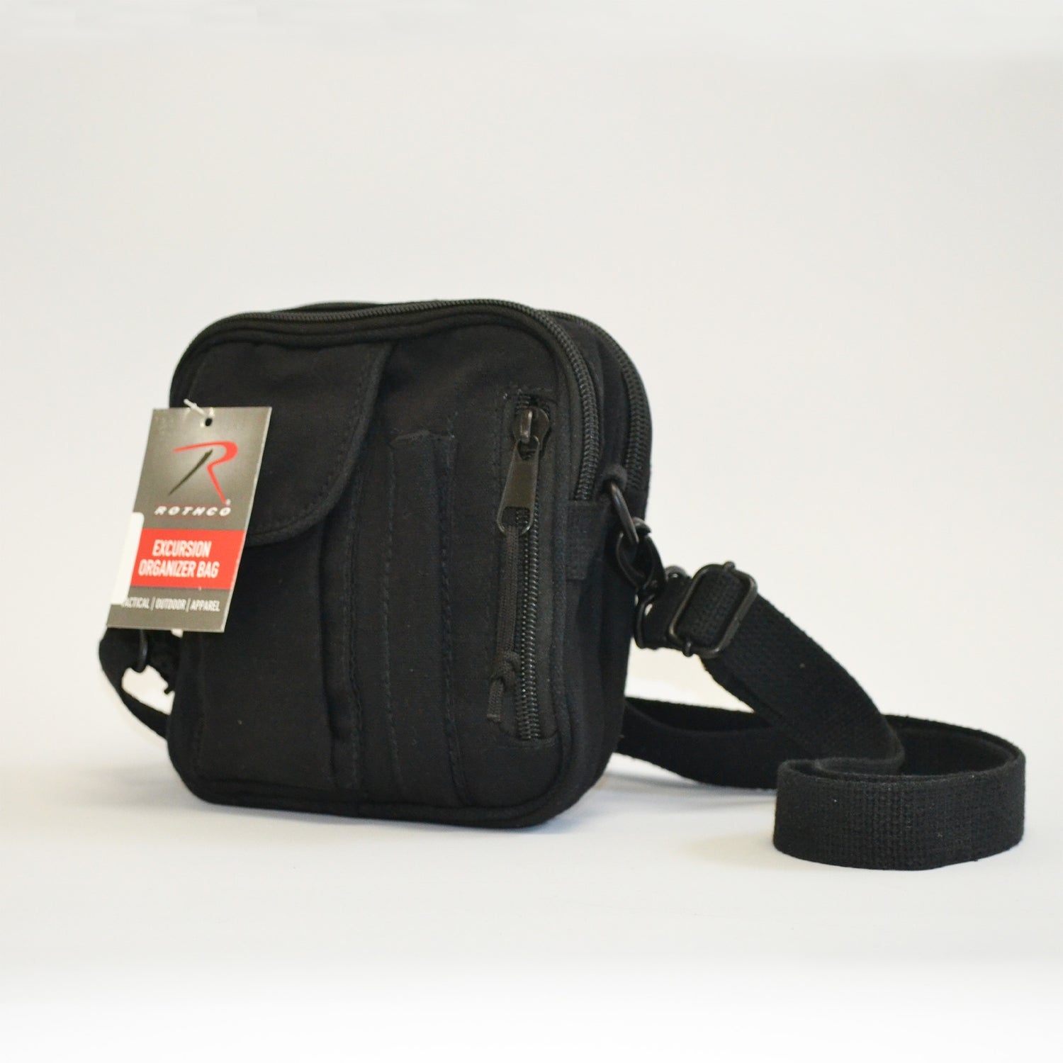 Small black bag with a flap pocket, a pencil skinny pocket and a zipper on the right side. Left side facing image