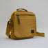 Light orange-brown colored bag with a front zipper and a slightly larger zipper, facing slightly to the right
