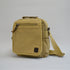 Khaki colored bag with a front zipper and a slightly larger zipper, facing a little to the left 