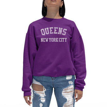 Woman in purple sweatshirt with the design of Words Queens, New York City written out in smaller words of the areas of Queens