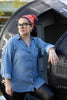 Woman posing outside NASA capsule wearing red head scarf