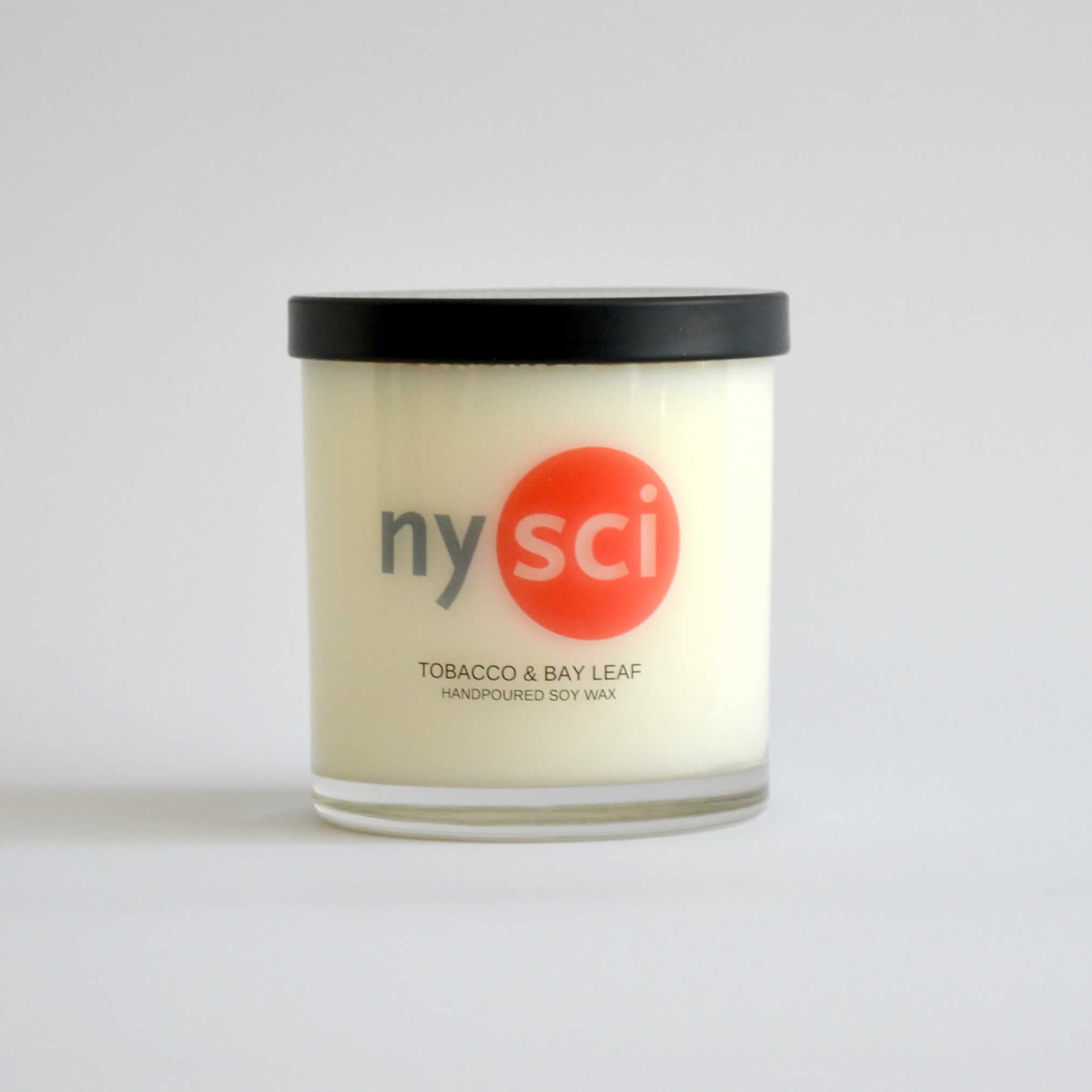 Candle jar with the nysci logo and the scent name on it of Tobacco and Bay Leaf