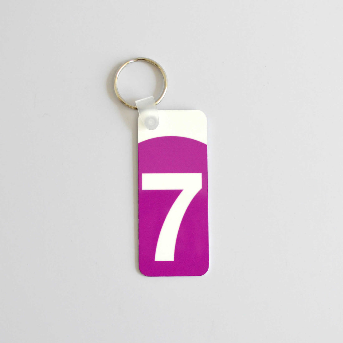 Keychain with the logo of the 7 train in purple