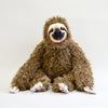 Fluffy sloth plush with long arms, sitting down. Front facing