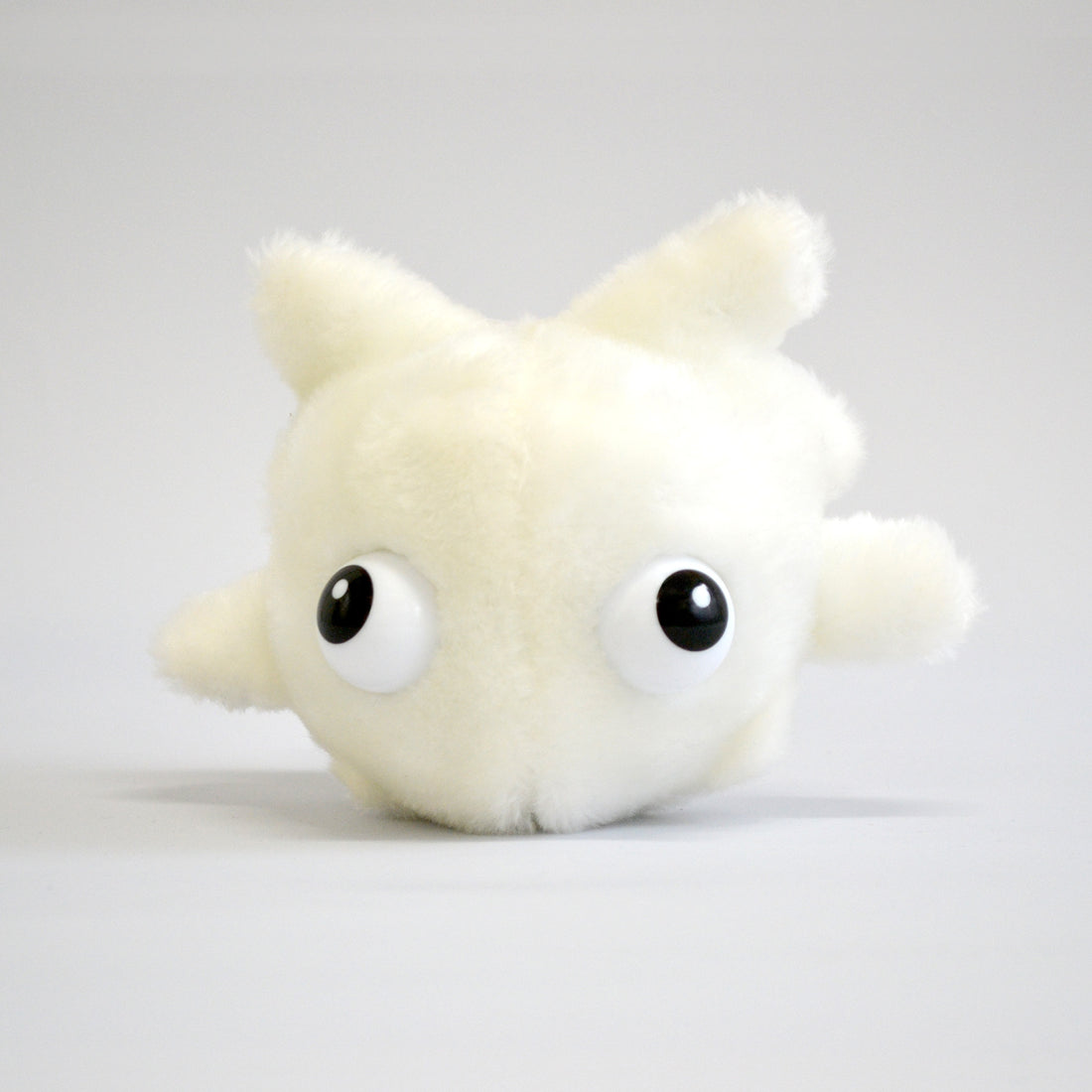 Plush white blood cell on white background with big eyes - front view