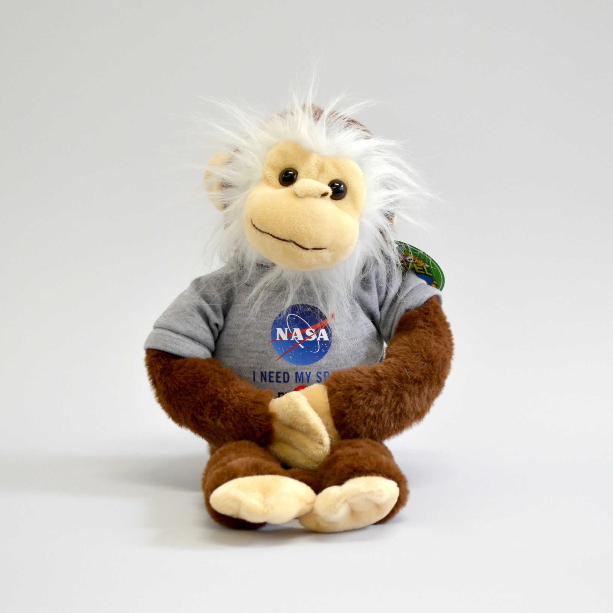 Stuffed animal chimp smiling and wearing a NASA t-shirt