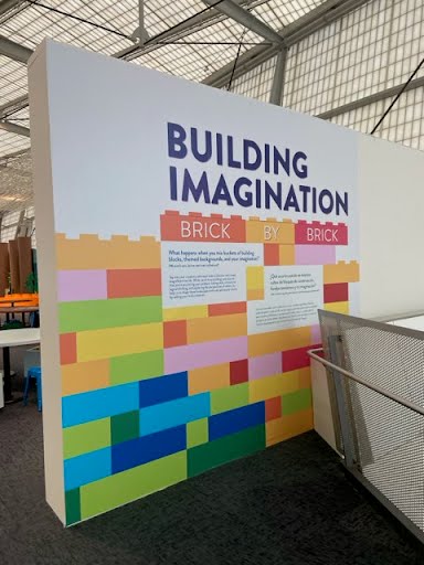 Colorful wall pained with the exhibit name, "BUILDING IMAGINATION"