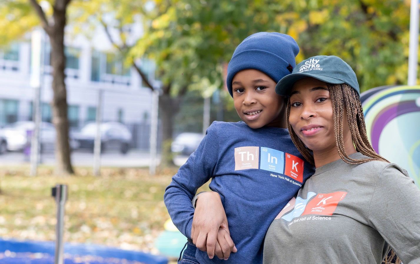 Two people standing together in an outdoor setting with a 'Wide Open Space' sign in the background.